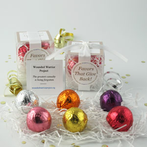 Foil Favors with white ribbons, clear boxes, assorted foil truffles on white shredding - corporate party favors